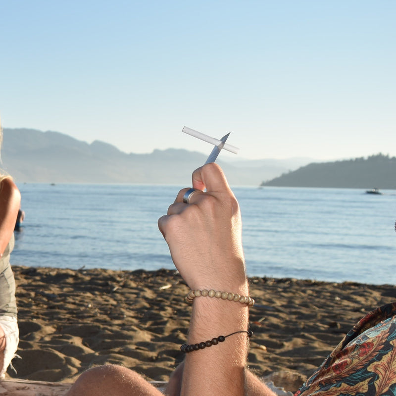 Stinky Pinky disposable cigarette and joint holder being used at the beach – eco-friendly portable smoking accessory for travel and outdoor use.